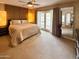 Spacious main bedroom with a ceiling fan, plush carpet, and glass doors with access to the pool at 2260 E Palmaire Ave, Phoenix, AZ 85020