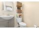 Powder bathroom with a tiled floor, single sink vanity and basket decor at 22959 W Cocopah St, Buckeye, AZ 85326