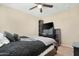 Comfortable bedroom featuring a well-made bed with a patterned quilt, a mounted TV, and a ceiling fan at 22959 W Cocopah St, Buckeye, AZ 85326