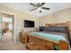 Bedroom featuring a wood-frame bed, ceiling fan, mounted TV, and an adjacent room with a closet at 22959 W Cocopah St, Buckeye, AZ 85326