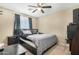 Cozy bedroom with a ceiling fan, bedside table, and a comfortable-looking bed with a decorative throw and pillows at 22959 W Cocopah St, Buckeye, AZ 85326