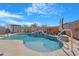 Backyard oasis showcasing a custom pool with a rock waterfall feature at 22959 W Cocopah St, Buckeye, AZ 85326
