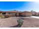 Single-story home featuring a well-kept desert landscape, arched windows, and attached garage at 26421 S New Town Dr, Sun Lakes, AZ 85248