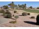 Landscaped community area with lush greenery, walking path, and golf course at 2662 S Springwood Blvd # 394, Mesa, AZ 85209