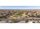 Aerial view of neighborhood with golf course, desert landscape and mountain views on a sunny day at 26880 W Sierra Pinta Dr, Buckeye, AZ 85396