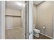 View of a bathroom that opens into a walk in closet, toilet, sink and tile floors at 26880 W Sierra Pinta Dr, Buckeye, AZ 85396