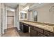 Bathroom featuring granite counters, dual sinks, dark cabinets, and tile floors, and a closet at 26880 W Sierra Pinta Dr, Buckeye, AZ 85396