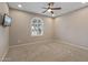 Empty bedroom with carpet flooring, and a window with an arched top and wood shutters at 26880 W Sierra Pinta Dr, Buckeye, AZ 85396