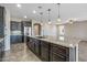 Gourmet kitchen with large island, dark cabinetry, and stainless steel appliances at 26880 W Sierra Pinta Dr, Buckeye, AZ 85396