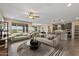 Bright living room with neutral colors, a ceiling fan, and an open floor plan into the kitchen at 26880 W Sierra Pinta Dr, Buckeye, AZ 85396