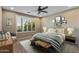 Bedroom with a ceiling fan, window with shutters, wood furniture and a decorative gallery wall at 26880 W Sierra Pinta Dr, Buckeye, AZ 85396