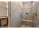 Close up of the tiled walk in shower with pebble floor, built in bench and shelving in the main bathroom at 26880 W Sierra Pinta Dr, Buckeye, AZ 85396