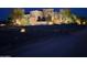 Night shot of well-lit home with desert landscaping including cacti and trees at 31409 N 166Th Pl, Scottsdale, AZ 85262
