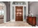 Inviting foyer with dark wooden front door, high ceiling, and tile flooring at 31409 N 166Th Pl, Scottsdale, AZ 85262