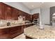 Well-equipped kitchen featuring granite countertops, stainless steel appliances, and custom dark wood cabinetry at 31409 N 166Th Pl, Scottsdale, AZ 85262
