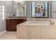 Bathroom featuring a soaking tub with tile surround, a granite vanity, and a decorative window at 31409 N 166Th Pl, Scottsdale, AZ 85262