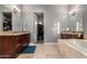 Elegant bathroom featuring double vanities, a soaking tub, and access to a walk-in closet at 31409 N 166Th Pl, Scottsdale, AZ 85262