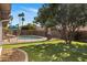 Lush backyard with a sparkling pool, well maintained artificial turf, and shaded by mature trees at 401 E Marconi Ave, Phoenix, AZ 85022