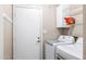 Functional laundry room equipped with washer, dryer, storage shelves, and convenient access to an exterior door at 401 E Marconi Ave, Phoenix, AZ 85022