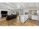 Open-concept living room with a fireplace, and kitchen featuring white cabinetry and stainless appliances at 401 E Marconi Ave, Phoenix, AZ 85022