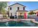 Backyard view of the home showcasing a pool with waterfall, covered patio, desert landscaping, and fencing at 4048 E Constitution Ct, Gilbert, AZ 85296