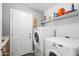 A functional laundry room with a washer, dryer, shelving, and a utility sink at 4121 E Ashurst Dr, Phoenix, AZ 85048