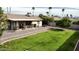 A well-maintained backyard with a covered patio, a lush lawn, and meticulous landscaping, perfect for outdoor living at 5123 E Beck Ln, Scottsdale, AZ 85254