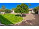 Lush backyard featuring a mature orange tree, green grass, and gravel, perfect for relaxation at 5123 E Beck Ln, Scottsdale, AZ 85254