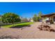 Well-maintained backyard featuring a lush lawn, mature trees, and gravel areas for outdoor enjoyment at 5123 E Beck Ln, Scottsdale, AZ 85254
