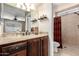 Bathroom featuring dark wood cabinetry, granite counters, and a step-in shower at 5123 E Beck Ln, Scottsdale, AZ 85254