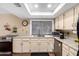 Well-lit kitchen with light colored cabinets, modern appliances and a large window overlooking the backyard at 5123 E Beck Ln, Scottsdale, AZ 85254