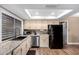 Well-lit kitchen with light colored cabinets, modern appliances and a large window overlooking the backyard at 5123 E Beck Ln, Scottsdale, AZ 85254
