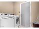 A clean laundry room featuring modern washer and dryer units, and a door leading to the garage at 5123 E Beck Ln, Scottsdale, AZ 85254