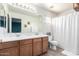 Double-sink bathroom with wood cabinets, tile flooring and a shower/tub combo at 5145 W Odeum Ln, Phoenix, AZ 85043