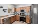 Bright kitchen featuring stainless steel appliances, wood cabinets, and a double sink at 5145 W Odeum Ln, Phoenix, AZ 85043