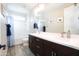 Well-lit bathroom featuring double vanity, wood cabinets, and a shower-tub combination at 632 W Springfield Pl, Chandler, AZ 85286