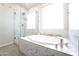 Bright bathroom featuring a walk-in shower, large soaking tub, and marble detailing at 632 W Springfield Pl, Chandler, AZ 85286