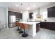 Modern kitchen featuring stainless steel appliances, dark wood cabinets, and a large island with barstool seating at 632 W Springfield Pl, Chandler, AZ 85286