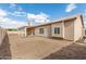 Wide backyard with a beige stucco house, covered patio, and ample space for customization at 824 N Williams Cir, Mesa, AZ 85203