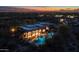 An aerial view of an estate with a pool and covered patio, set against city lights and desert mountains at 8540 E Mcdowell Rd # 125, Mesa, AZ 85207