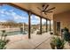 Covered patio area with rustic columns, overlooking the pool and lush backyard landscape at 8540 E Mcdowell Rd # 125, Mesa, AZ 85207