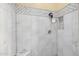 Updated shower featuring marble tile walls, built in bench, and modern fixtures at 8540 E Mcdowell Rd # 125, Mesa, AZ 85207