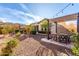 Spacious backyard with a pergola covered seating area, manicured landscaping, and gravel ground cover at 9013 S 15Th Way, Phoenix, AZ 85042