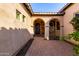 Inviting home entrance with arched doorways, brick-paved walkway, and stone accents at 9013 S 15Th Way, Phoenix, AZ 85042