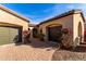 Dual garage home exterior with well-manicured bougainvillea and a brick-paved driveway at 9013 S 15Th Way, Phoenix, AZ 85042