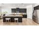 Modern kitchen featuring dark cabinetry, a spacious granite island, and stainless steel appliances at 9013 S 15Th Way, Phoenix, AZ 85042