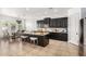 Modern kitchen with granite island seating, dark cabinetry, stainless steel appliances, and adjacent dining area at 9013 S 15Th Way, Phoenix, AZ 85042