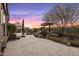 Expansive backyard with manicured landscaping, a relaxing pool, and a view of the sunset sky at 10902 N 138Th Pl, Scottsdale, AZ 85259