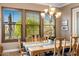 Bright dining room with a chandelier, table set, and views through shuttered windows at 10902 N 138Th Pl, Scottsdale, AZ 85259