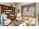 Warm living room featuring comfortable seating, bookshelves, and scenic window views at 10902 N 138Th Pl, Scottsdale, AZ 85259